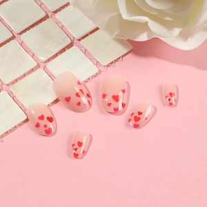 Cute heart pattern press-on nails in nude pink with red hearts and floral decor