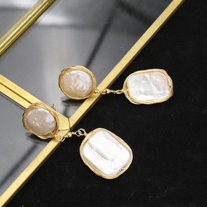 Detailed close-up of baroque pearls with handmade gold wire wrapping on black velvet