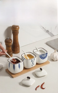 Japanese ceramic spice jars detail with hand-painted patterns and wooden base