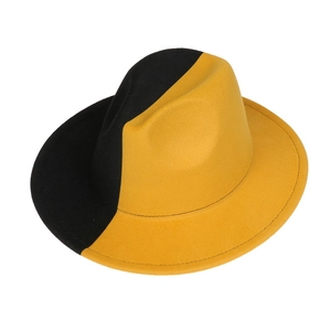Detail of wide brim fedora hat featuring bold black and yellow color block design