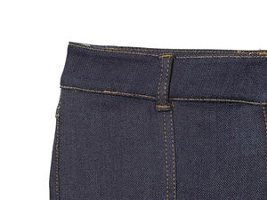 Détail de la taille d'un jean bleu foncé montrant les coutures jaunes et la texture du denim