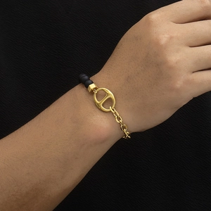 Golden titanium steel chain bracelet with matte black beads and anchor link on wrist