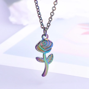 Macro view of a colorful iridescent rose pendant necklace with detailed leaves on a fine chain