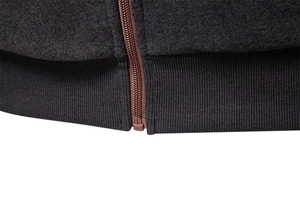 Macro shot of elastic ribbed hem and smooth brown zipper on men's thermal hoodie
