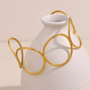 Minimalist 18K gold plated stainless steel hollow circular bangle on white vase