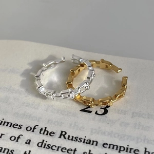 Macro shot of silver and gold chain rings on a vintage book page for aesthetic jewelry detail