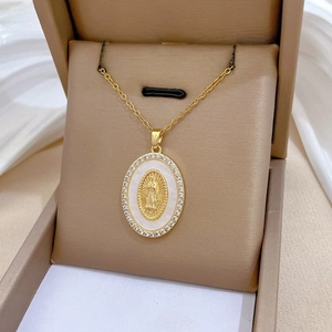 Macro shot of gold Virgin Mary pendant with shell inlay and diamonds in a jewelry box