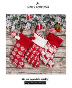 Three knit Christmas stockings with snowflake and reindeer patterns on a wood background