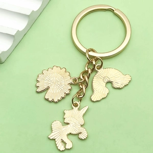 Detail of gold keychain with colorful rainbow, unicorn, and daisy flower charms