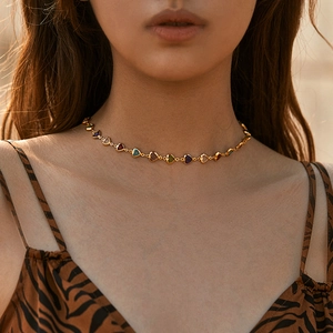 Choker necklace featuring colorful heart-shaped glass stones on a gold metal chain