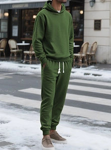 Close-up of green men's tracksuit showing textured knit jacquard fabric and hood details