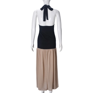 Detail eines rückenfreien Kleides mit schwarzem Halter-Top und beigefarbenem Faltenrock
