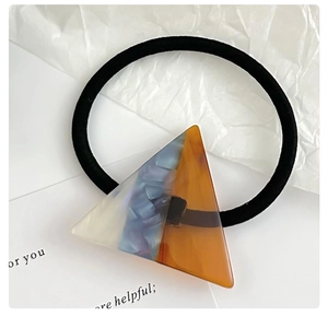 Detailed shot of elastic hair tie with amber and cream acrylic star charm decoration