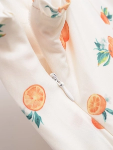 Vue détaillée de la fermeture éclair invisible sur une robe à imprimé floral d'oranges