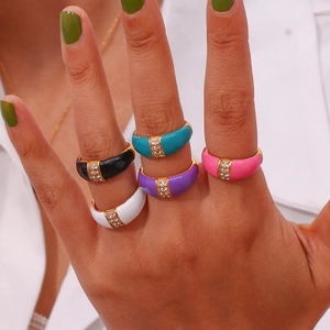 Close-up of five colorful enamel rings with 18K gold plating and diamond accents