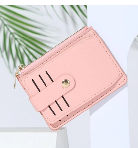 Detailed view of a pink leather card holder with gold zipper and stitching accents