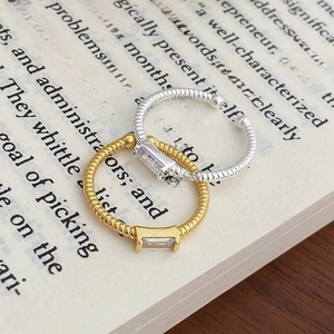 Minimalist s925 silver twist ring with emerald-cut zircon on vintage book pages