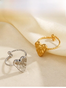 Dettaglio di anelli a cuore oro e argento con trama martellata su tessuto di seta