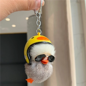 Close-up of plush grey duck keychain with yellow helmet and sunglasses detail