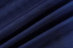Vue détaillée de la texture du tissu en maille crochet bleu foncé et du motif de tricot aéré
