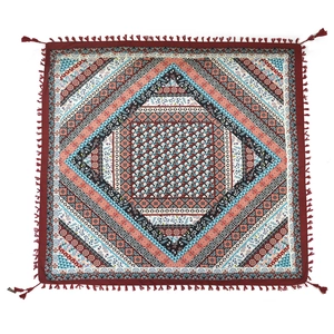 Detail of bohemian jacquard square scarf featuring ethnic prints and red tassel edges