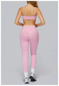 Rear view of high-waisted yoga leggings and sports bra in pink heathered knit fabric
