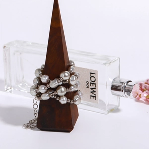 Detailed view of gray baroque pearls and silver beads on a wooden cone display