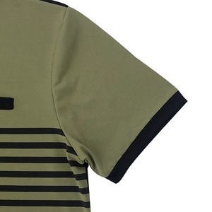 Detail of olive green short sleeve with black stripes and contrast piping on the cuff