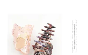 Detail of pink acetate heart hair claw clip with star patterns and sparkling rhinestones