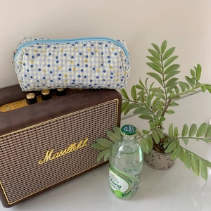 Detailed view of quilted blue and yellow checkered pencil case with zipper closure