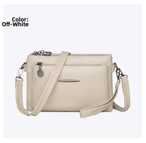 Detail of creamy white PU leather crossbody bag with multiple zippers and pebble texture