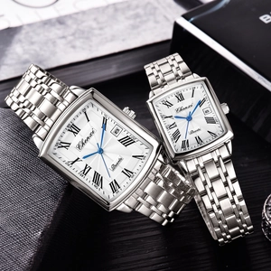 Close-up of silver stainless steel couple watches with white square dials and blue hands