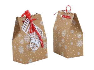 Detail of kraft paper Christmas gift bags with snowflake patterns and red ribbon bows