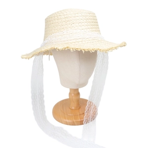 Detail of a straw hat featuring fringe edges and elegant white lace ribbon ties