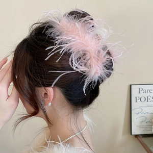 Detail of elegant pink faux feather hair claw clip on model for a romantic hair style