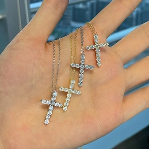 Close-up of four s925 silver cross necklaces in gold and silver with cubic zirconia stones