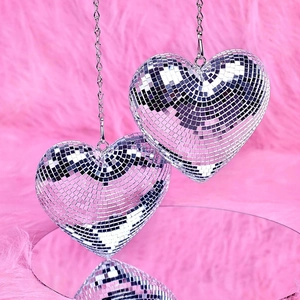 Close-up of hanging heart-shaped silver disco balls with mirror mosaic and metal chain