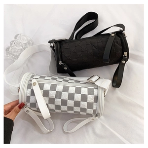 Close-up of black and checkered cylinder bags with pleated texture and wide straps