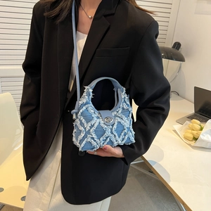 Chic blue denim crossbody handbag with distressed quilted pattern and leather strap