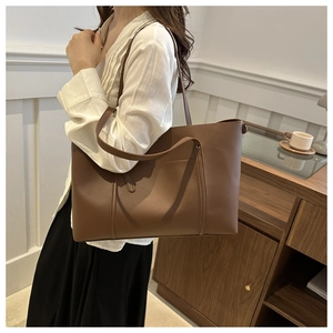 Brown leather large capacity tote bag shown on model for a natural commute style