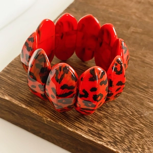 Detailed view of polished red leopard print resin links with vibrant glossy finish