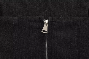 Dettaglio della cerniera in metallo argentato sul tessuto del bustier in denim