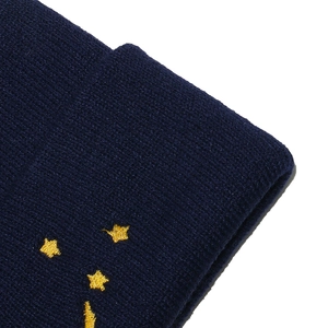 Gros plan détaillé de la broderie étoile jaune sur un bonnet en tricot bleu marine