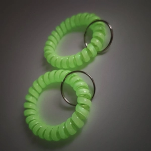 Detail view of two neon green matte spiral wristbands with silver metal rings