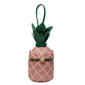 Macro detail of pineapple crossbody bag with pink lattice texture and gold studs