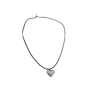Minimalist silver heart pendant necklace with black cord strap on a clean white background