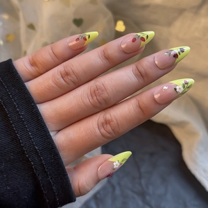 Detailed view of floral press-on nails with 3D ladybug, strawberry and pearl accents