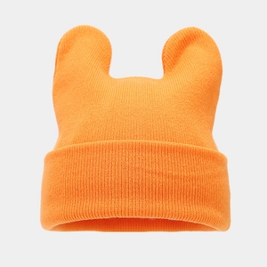 Detail of orange knitted beanie with cute animal ears and textured ribbed cuff