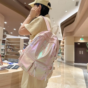 Holographic pink school backpack with multi-pocket design shown on model in bookstore