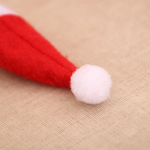 Detail of red and white mini Christmas hat showing soft felt texture and white pompom